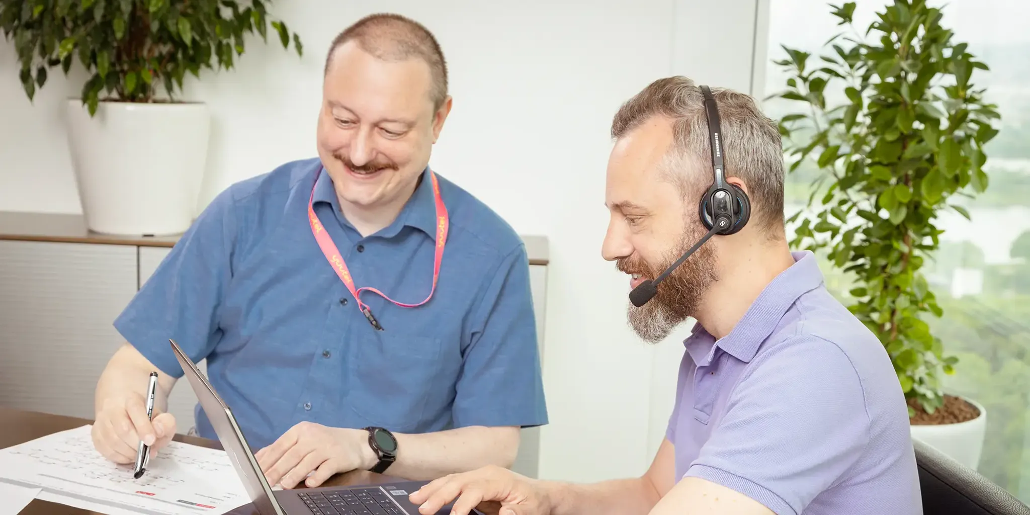 Techniker in Besprechung mit Headset und Laptop