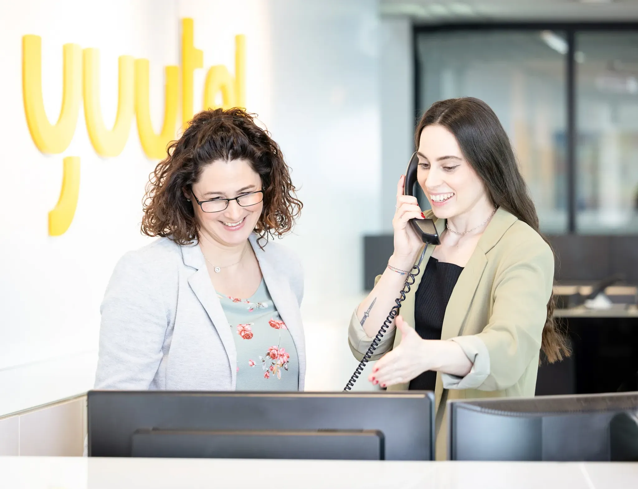 Zwei Mitarbeiterinnen betreuen telefonisch Kunden am yuutel Empfang