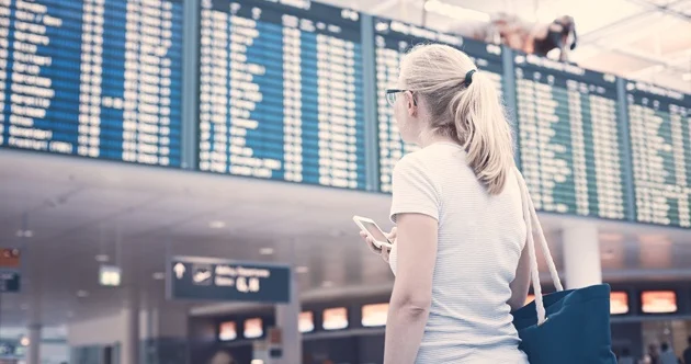Frau am Flughafen mit Smartphone