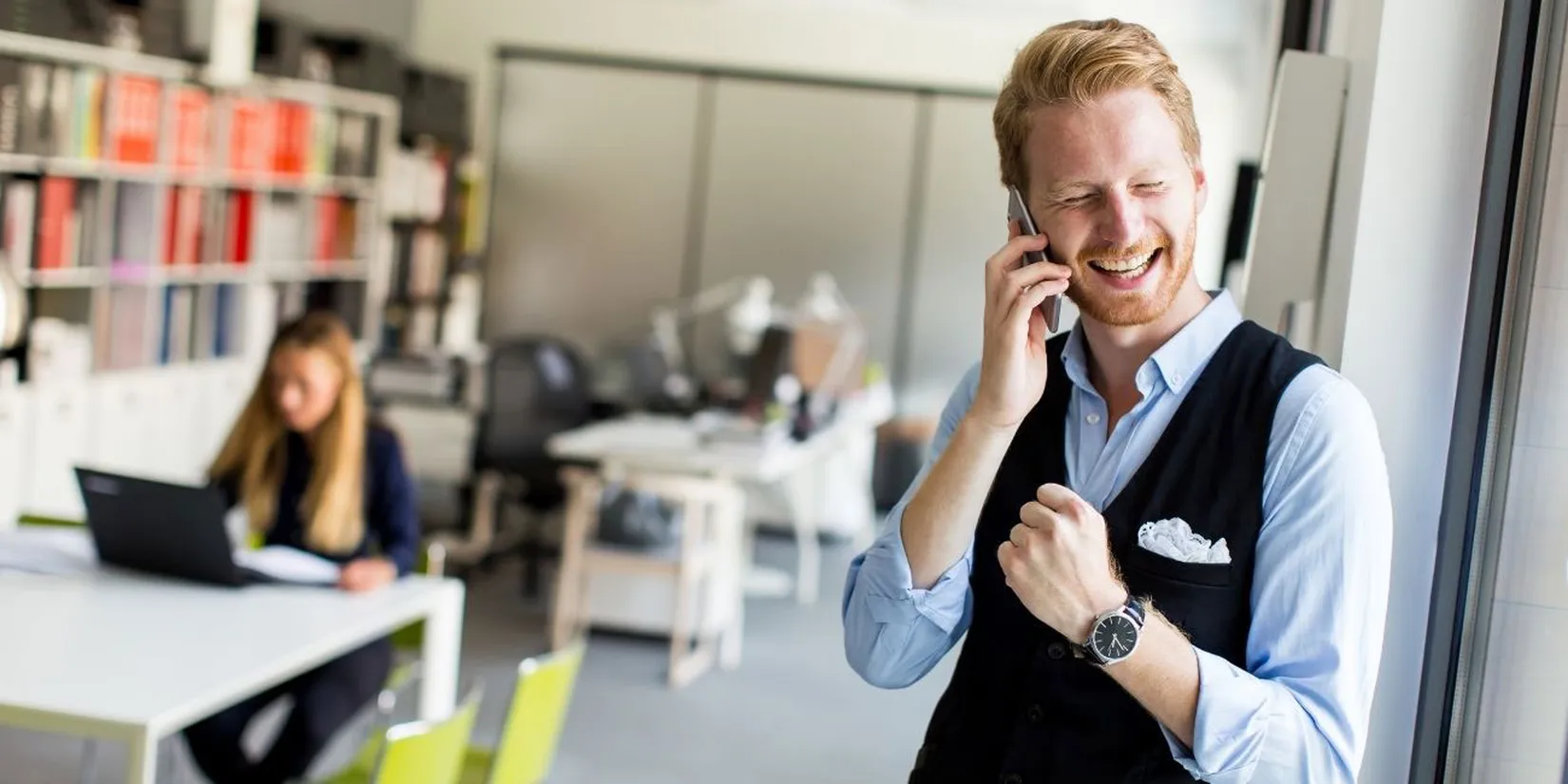 Geschäftsmann freut sich beim Telefonieren mit Smartphone