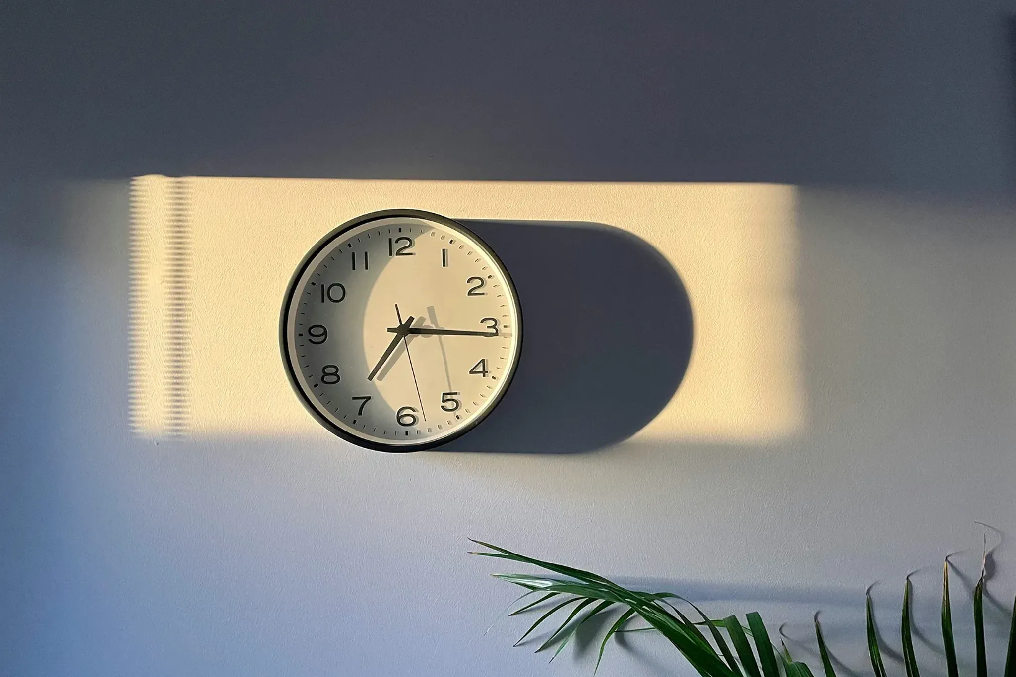 Uhr an der Wand zeigt Uhrzeit an